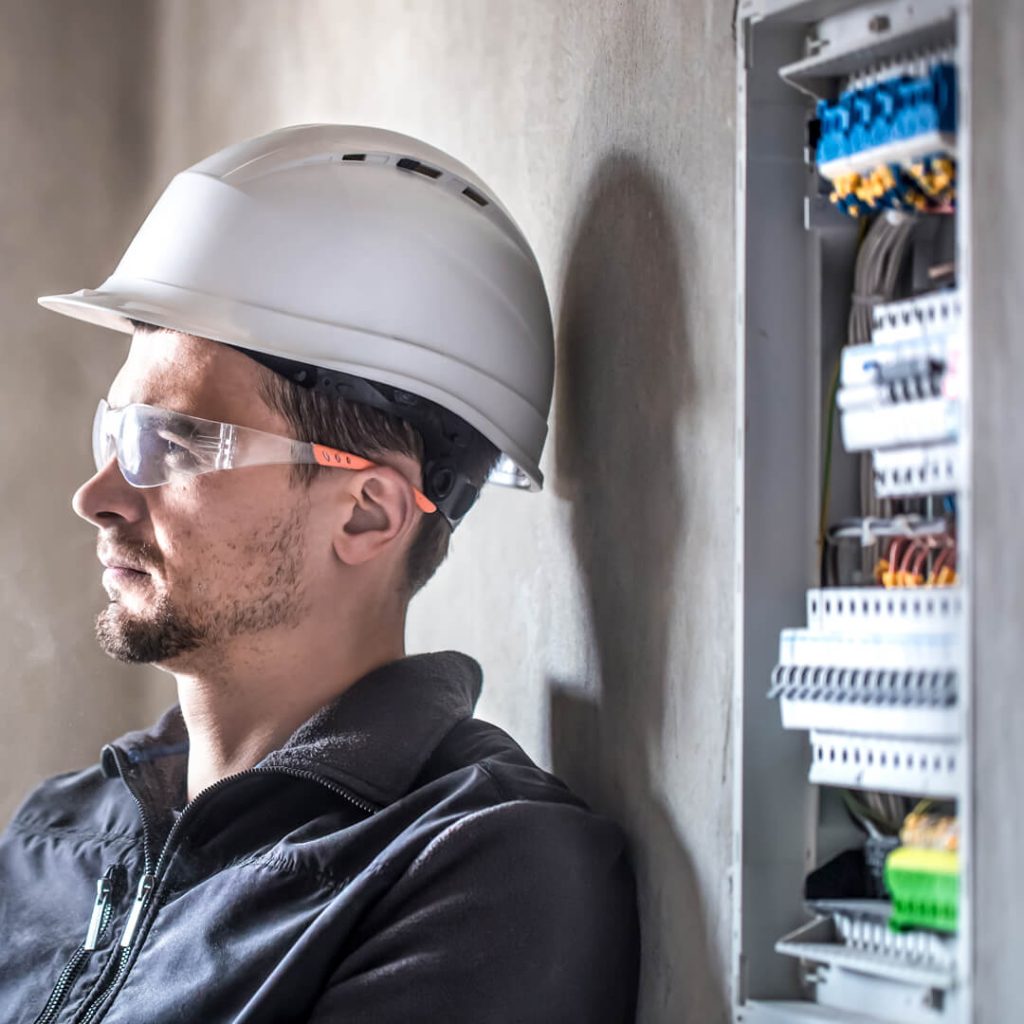 male-electrician-working-switchboard-with-electrical-connection-cable